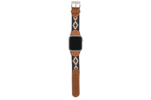 The LA MATERA - CORBINA Apple Watch Band in silver pairs artisan brown leather with a black fabric section, beige geometric pattern, and red stitching.