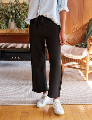The FRANK & EILEEN BELLA Italian Sweatpant in black features a drawstring waist, side seam detail, and a lightly frayed hem, shown flat on a light textured background.