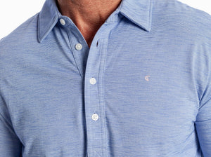 A smiling man with short gray hair and a beard is wearing the CRIQUET - BRRR° Long Sleeve Range Polo in Lapis Blue, standing against a plain white background.