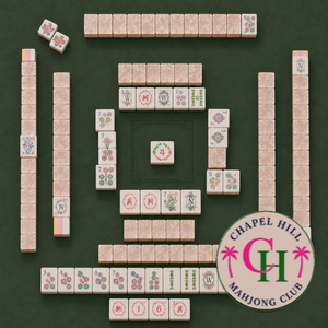 Mahjong tiles are arranged on a green table featuring the “FEARRINGTON VILLAGE” logo for MAHJONG NIGHT AT FEARRINGTON in the lower right corner. Various suits and honor tiles are neatly organized in rows and squares, reflecting the popular style of play enjoyed by participants from both Fearrington Village and Chapel Hill.