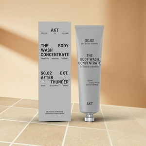 A partially squeezed purple tube labeled AKT London, featuring “BODY WASH CONCENTRATE AFTER THUNDER,” highlights long-lasting use—one tube lasts up to 3 months. Packaged in 100% recyclable aluminum with zero plastic, this vegan, plastic-free body wash offers a powerful and concentrated 3x formula with no added water.