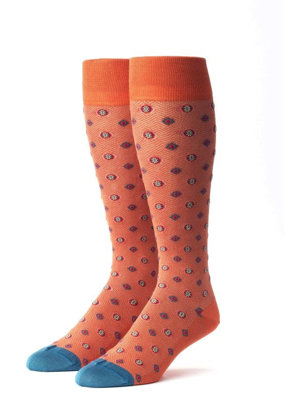 The EDWARD ARMAH - ORANGE RED TEAL FOULARD SOCKS feature knee-high orange socks with small blue and red circular patterns, orange cuffs and heels, and blue toes, shown against a white background.