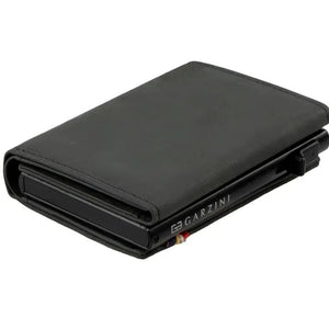 A GARZINI Slim Trifold RFID-blocking leather wallet in carbon black is shown closed, featuring a minimalist design, metal card holder, coin pocket, and the "GARZINI" logo on the side.
