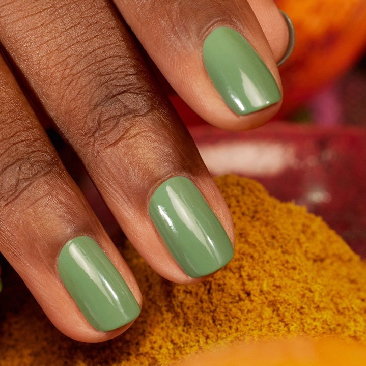 A bottle of MANUCURIST INC GREEN™ Nail Polish in the shade “Artichoke,” a green, quick-dry polish with intense color.