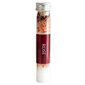 Three BOTANICAL BATH SALT TUBES - ROSE by GIFTEN MARKET filled with layered pink and white rose bath salts and dried rose petals are arranged on a marble surface, with some of the mineral-rich salts and petals scattered around.