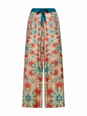 FRANCO FERRARI's ALOE SILK TROUSER is high-waisted with a wide-leg cut, showcasing a resort-style floral print in vibrant orange, teal, and pink on a light background with large blossoms for an eye-catching look.