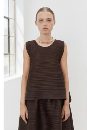Close-up of MEIMEIJ Plisse Sleeveless Top's dark textured fabric displays a finely woven pattern. The consistent monochrome color and texture, with subtle weave variations, reflect minimalist elegance.