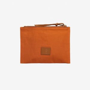 The INOUI Editions Embroidered Pouch Paris 9th Arrondissement by INOUI showcases stacked and open books, a tiny horse figurine, and a “NOUI EDITIONS” ribbon on beige fabric. It features a brown zipper with an Italian leather pull tab.
