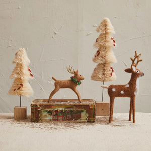 Create a festive scene with CREATIVE COOP FELT STANDING DEER and cream-colored decorative trees with red accents, artfully arranged on a vintage-style box—perfect for seasonal home decor.