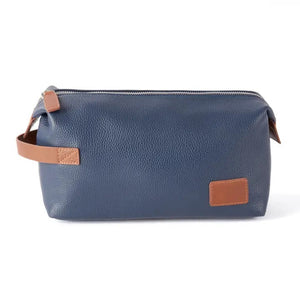The BEYBERK INTERNATIONAL VIENNA TOILETRY BAG IN NAVY is a rectangular leather bag with a brown handle and patch accents, featuring a silver top zipper. This stylish travel accessory sits on a white background.