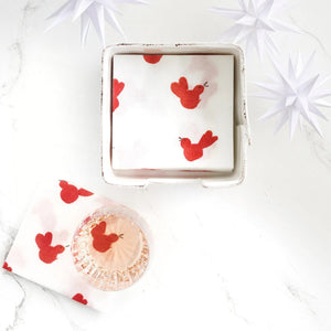RED BIRD COCKTAIL NAPKIN: white cocktail napkins featuring a repeating pattern of small, hand-painted style red birds.