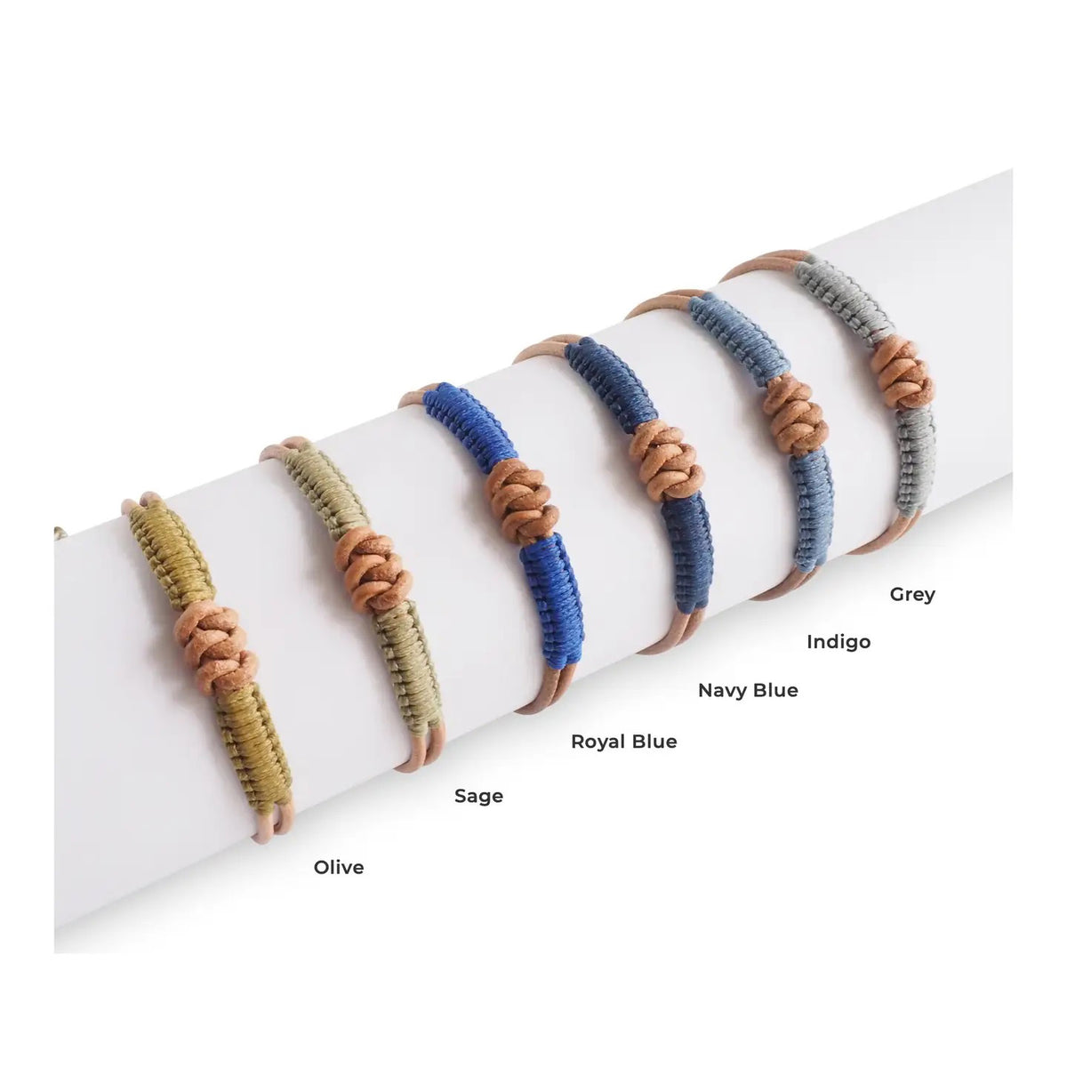 A close-up of a wrist wearing the MAKARLA Men's Knot Leather Bracelet, adjustable in olive green, featuring knotted details. The person is dressed in a white shirt and blue jeans.