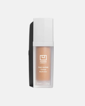 A bottle of U BEAUTY - THE SUPER TINTED HYDRATOR SHADE 8, featuring a white cap and frosted clear body with beige liquid, stands upright against a light gray background.