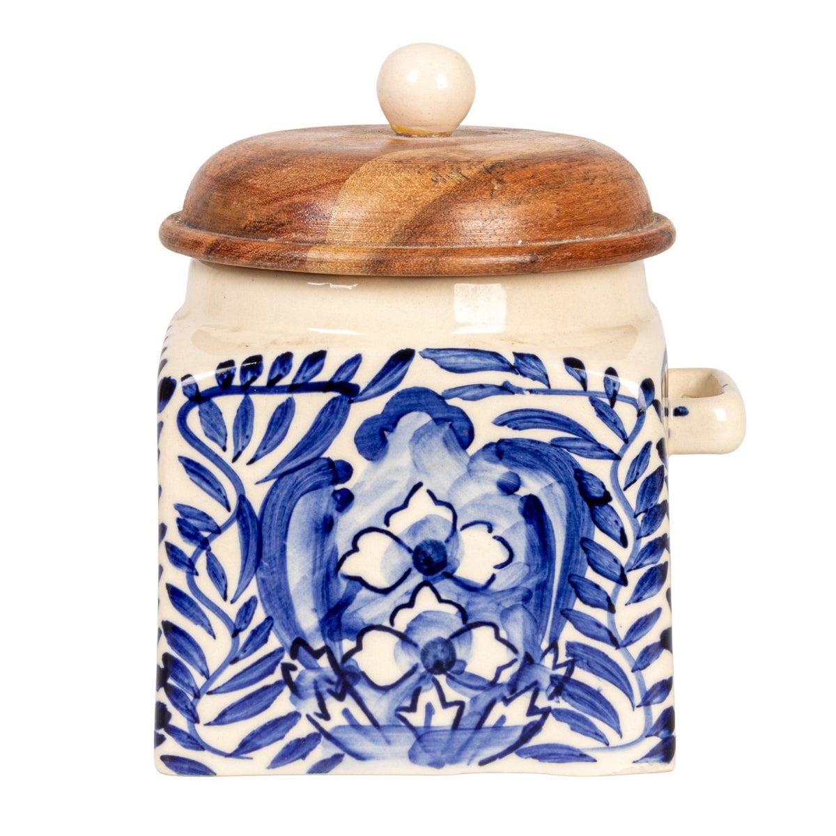 A close-up of the CREATIVE COOP HAND-PAINTED STONEWARE CANISTER WITH LID AND SPOON shows blue floral designs on cream stoneware and an acacia wood lid—an elegant farmhouse kitchen accent.