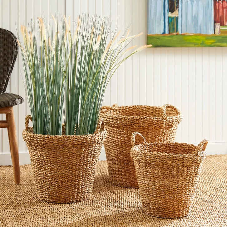 The NAPA HOME AND GARDEN Seagrass Tapered Basket with Handles and Cuff, Large, is shown from above, highlighting its natural seagrass texture and expert craftsmanship on a matching surface.