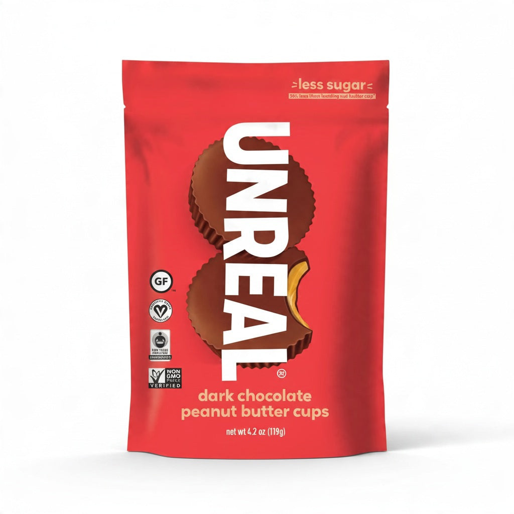 A purple bag of UNREAL DARK CHOCOLATE PEANUT BUTTER CUPS, featuring images of the cups and a peanut. Labels indicate it’s low sugar, gluten-free, vegan, and non-GMO. Net weight is 3.2 oz (91g).