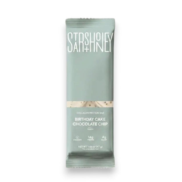 A wrapped STARS+HONEY - BIRTHDAY CAKE CHOCOLATE CHIP bar rests on a beige surface. The light blue packaging, branded with the STARS+HONEY logo and white text, displays nutrition details and hints at the irresistible flavors of vanilla yellowcake and natural sprinkles inside.