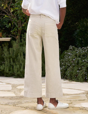 The FRANK & EILEEN Wexford Wide Leg Linen Pants in Cement are showcased against a light textured background. These Italian Performance Linen pants feature a fitted waist with belt loops and a zip fly with button closure. The bottom hems are neatly finished, providing a clean, tailored appearance.