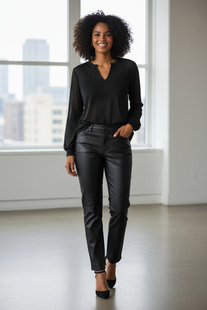 A woman with long brown hair wears the KINROSS CASHMERE SHIMMER SPLITNECK TOP, a semi-sheer black blouse with subtle lurex sparkles, paired with black leather pants against a plain white background.