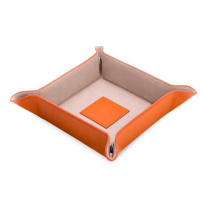 The LEATHER VALET IN ORANGE by BEYBERK INTERNATIONAL is a square leather tray with beige pigskin lining and raised edges, perfect for storing small items like keys or coins.