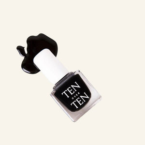 A glass bottle of TENOVERTEN - NAIL POLISH from the brand TEN OVER TEN, featuring a white cap and a dusty pink nail color. The front label displays "TEN OVER TEN" in white uppercase letters. This vegan, eight-free formula ensures both beauty and peace of mind. The background is plain and light-colored.