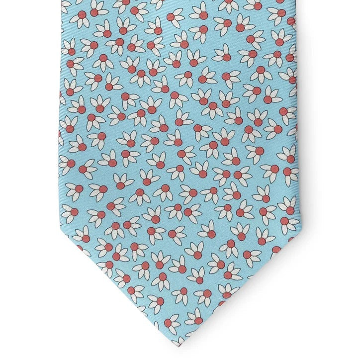 A rolled-up aqua silk tie by Bird Dog Bay, the Peter-Blair Spike Printed style, featuring a floral print in white, pink, and green.