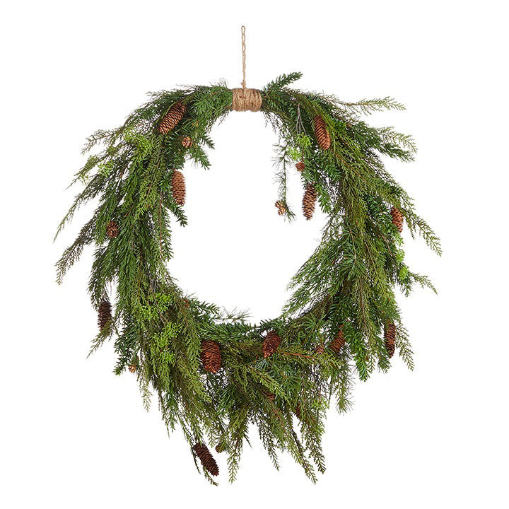 The OVAL CEDAR &amp; PINECONE WREATH 36&quot; by RAZ IMPORTS showcases a natural and rustic design, featuring green cedar branches adorned with brown pinecones. Entwined with rattan and hung on a simple string, this festive decoration brings a seasonal charm to any setting.