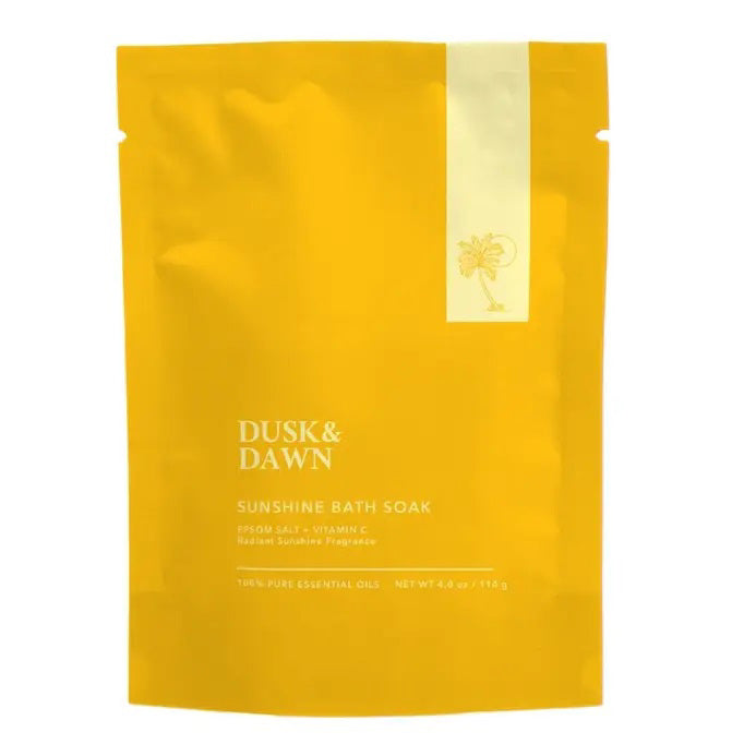 A bright yellow, resealable pouch labeled "GIFTEN MARKET Sunshine Bath Soak," enhanced with the calming scent of organic lavender. The text also mentions "Epsom Salt + Vitamin C," "Natural Sunshine Fragrance," and "100% Pure Essential Oils." The net weight is 9.4 oz (266 g), with a small sun icon featured on the package.