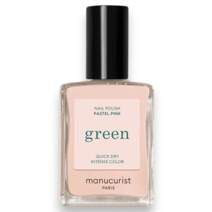 A hand with neatly manicured nails—polished with MANUCURIST - GREEN™ Nail Polish in Pastel Pink by MANUCURIST INC—rests on light brown sand, a few grains clinging to the skin.