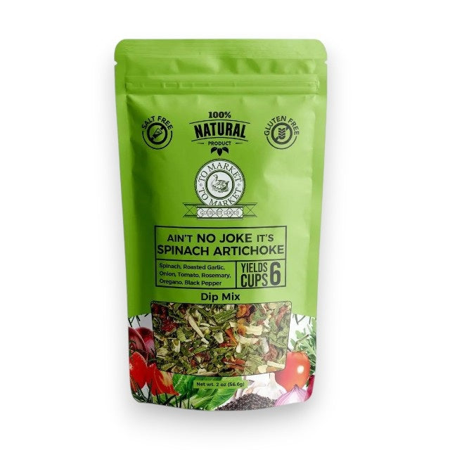 A green bag of TO MARKET - SPINACH ARTICHOKE DIP MIX from TO MARKET- DIPS &amp; SPREADS stands behind a white bowl filled with spinach artichoke dip and crackers. Made with roasted garlic and natural ingredients, this gluten free mix makes six cups.