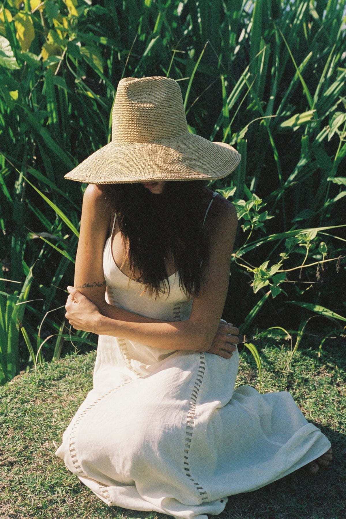 The WYETH HATS - LINA Raffia Sun Hat in Natural by WYETH features a packable, ultra wide brim and rounded crown, shown against a plain white background.