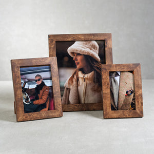 The ZODAX BURL WOOD PHOTO FRAME 8X10 showcases a portrait of a woman in a white fuzzy hat and cream coat, gazing sideways against a softly blurred backdrop.