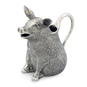 The VAGABOND HOUSE - PEWTER HAPPY PIG CREAMER, made from luxury-grade pewter, features pointed ears and detailed design. Its handle stretches from the back, revealing milk inside. This elegant piece by VAGABOND HOUSE sits on a plain white background.