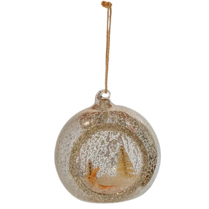A MERCURY GLASS DIORAMA ORNAMENT WITH DEER, BOTTLE BRUSH TREES AND GLITTER featuring a miniature deer and bottle brush tree inside a mercury glass globe with a snowy diorama.