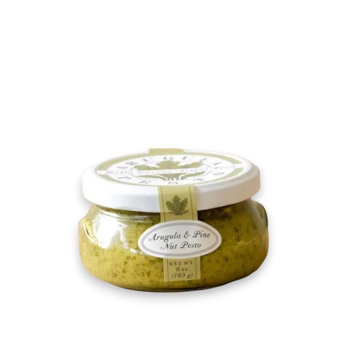 A small glass jar with a white lid, containing green pesto. The label on the jar reads "BELLA CUCINA - ARUGULA AND PINE NUT PESTO" and indicates a net weight of 6 ounces (169 grams). With hints of parmesan cheese, the jar is placed on a light-colored surface, reflecting its image underneath.