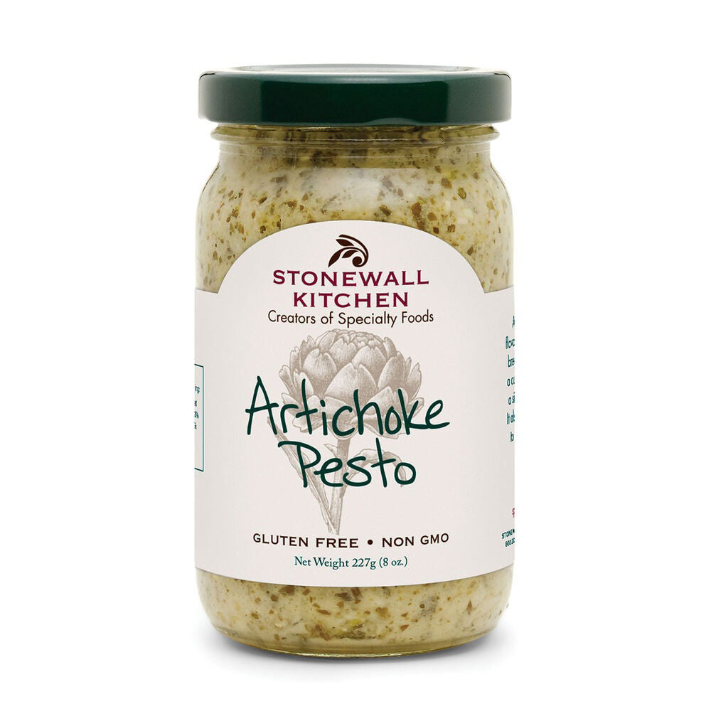 A jar of STONEWALL KITCHEN - ARTICHOKE PESTO with a green lid. The label displays the brand name, "STONEWALL KITCHEN," and "Creators of Specialty Foods" above an illustration of an artichoke. Text below reads "Artichoke Pesto," "Gluten Free," "Non GMO," and "Net Weight 227g (8 oz.). Perfect for a Mediterranean-inspired, healthy meal.