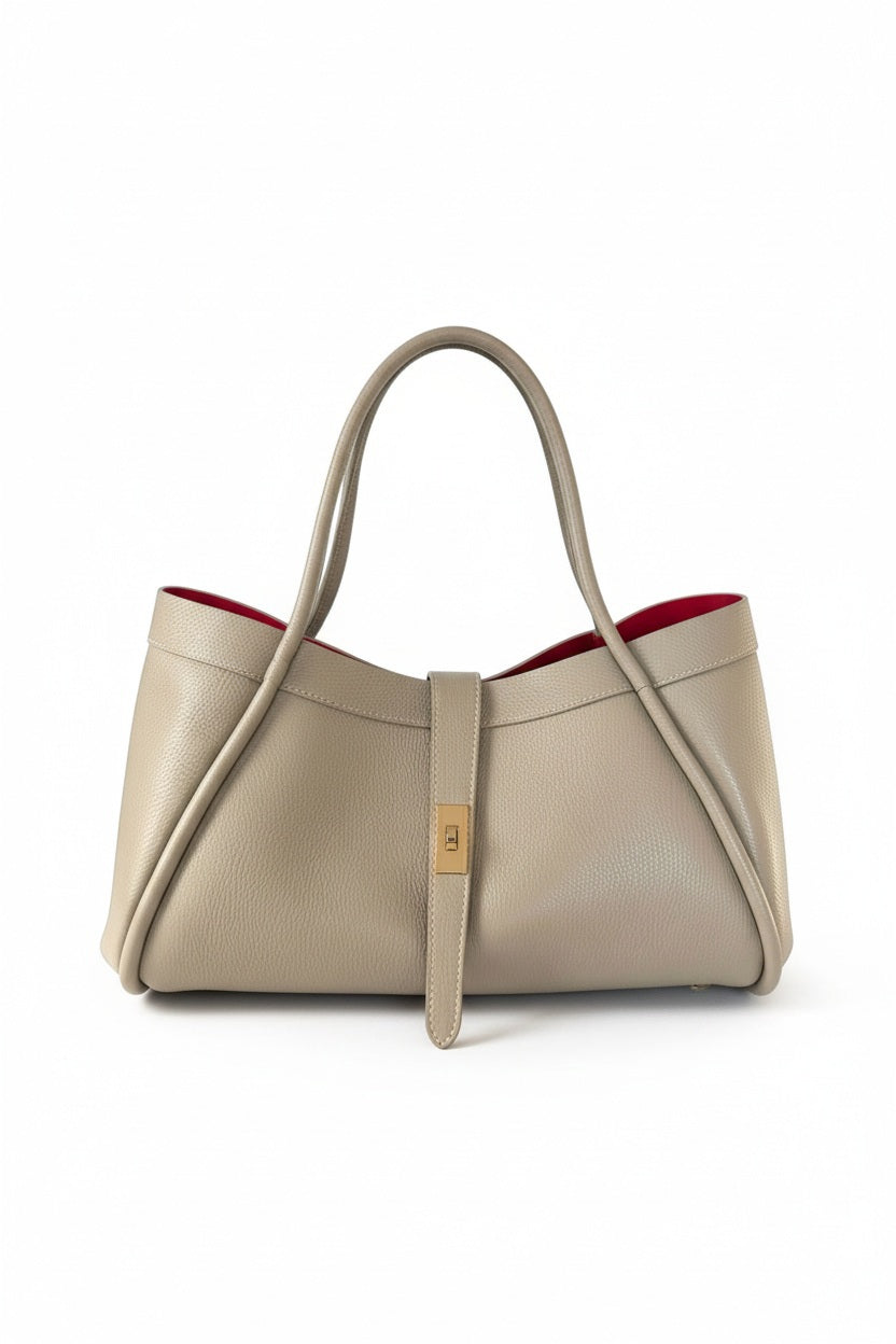 THE PORTICO LEATHER HANDBAG IN TAUPE by LE BORSETTE, a taupe Italian designer handbag with two top handles, a gold-toned clasp closure, and a red interior.