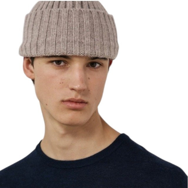 A nut-colored ribbed beanie by HARTFORD, expertly crafted from a soft cashmere and wool blend, featuring a folded cuff and shown against a plain white background, exuding luxurious knitwear appeal.