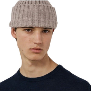 A nut-colored ribbed beanie by HARTFORD, expertly crafted from a soft cashmere and wool blend, featuring a folded cuff and shown against a plain white background, exuding luxurious knitwear appeal.