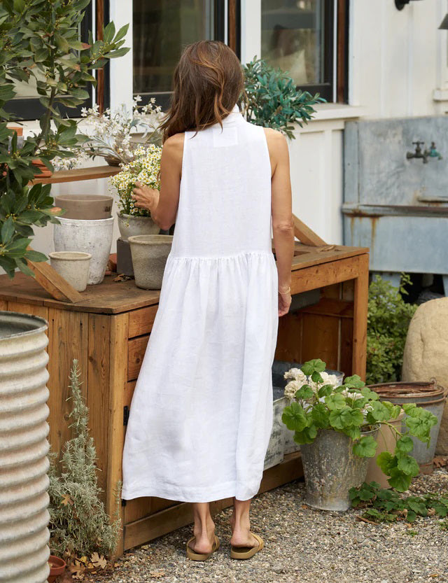 The FRANK &amp; EILEEN - DAPHNE SLEEVELESS POPOVER DRESS is a sophisticated maxi dress in washed linen, featuring a collar and V-neck. This elegant dress by FRANK &amp; EILEEN showcases a fitted bodice, a gathered flared skirt, and convenient side pockets. It is displayed against a white background.
