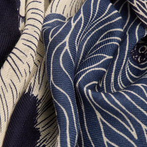 The INOUI EDITIONS TOUTOU DOGS WOOL SCARF IN NAVY features stylized blue and white dogs with fluffy, textured fur, arranged closely in a vertical frame, inspired by the brand INOUI's signature design.