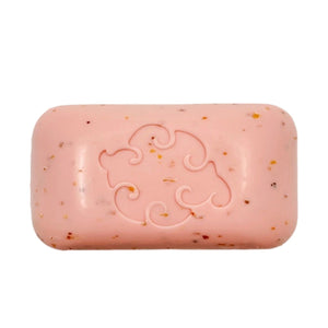 Five vibrant BAUDELAIRE bars of soap, including the GRAPEFRUIT LOOFA BATH SOAP 5OZ, rest elegantly on a light surface—some nestled in cardboard boxes. The collection features pink, white, yellow, green, and brown soaps with smooth, curved shapes. Among the selection are natural seaweed and citrus exfoliating varieties, all thoughtfully crafted with sustainable palm oil for an eco-friendly touch.