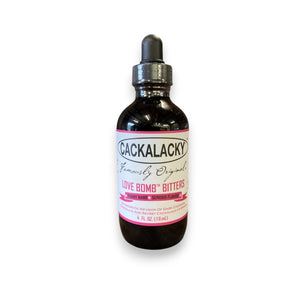 A 4 oz. dark glass dropper bottle of CACKALACKY - LOVE BOMB BITTERS from CACKALACKY, featuring pink and white text on the label, sits against a plain white background—an ideal addition to your aromatic cocktail bitters collection.