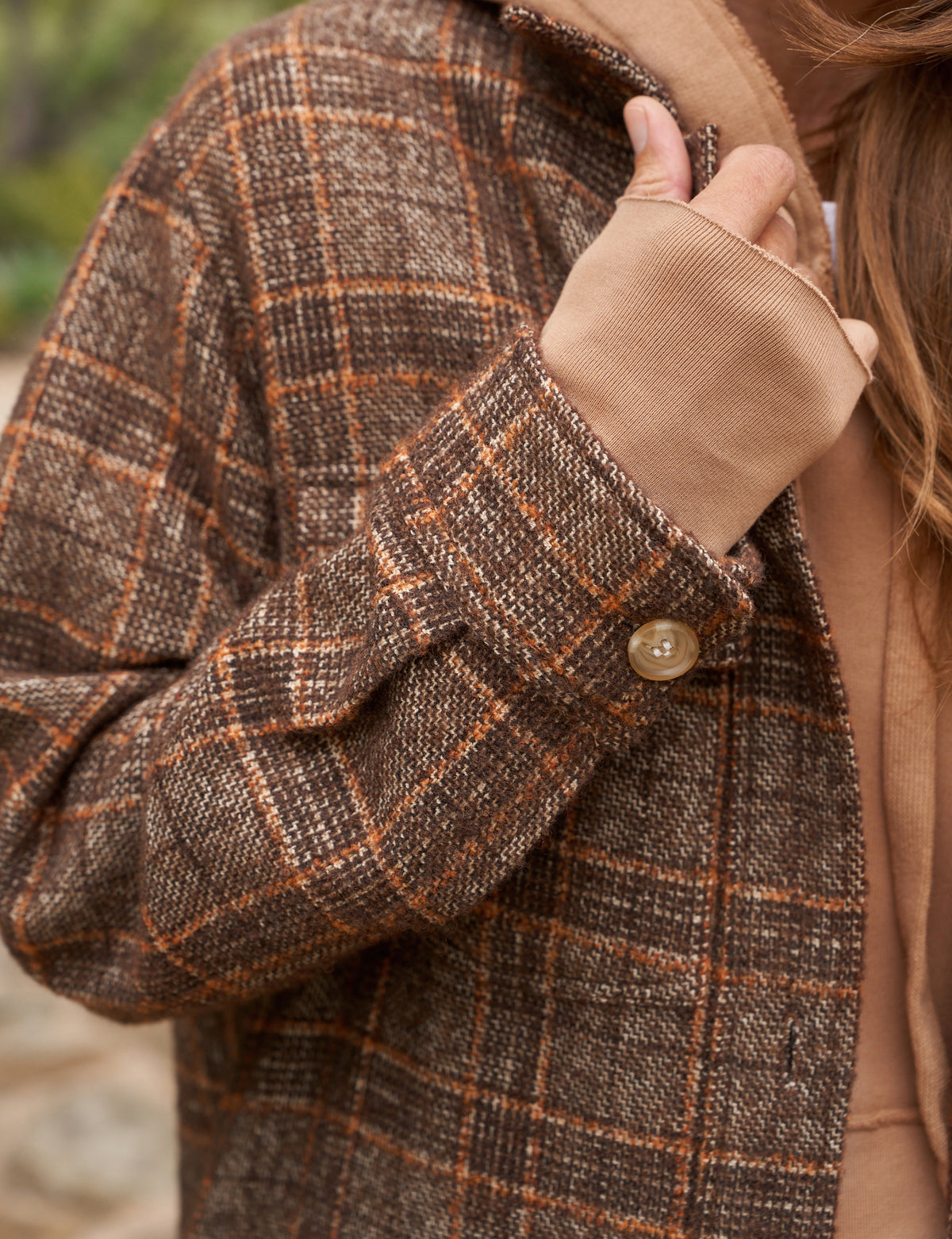 The Gavin Italian Boucle Shirt Jacket from Frank &amp; Eileen is a long, plaid coat in shades of brown with an oversized fit. Made from luxurious pre-washed wool, the coat features a collared neckline, button closure, and two large front pockets. Sleeves are rolled to mid-length and the fabric showcases a textural, woven appearance. The tag inside reads &quot;Frank &amp; Ellen.