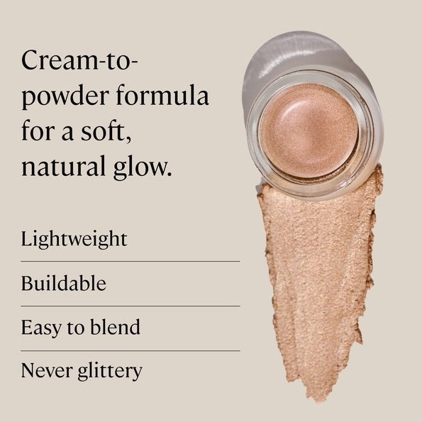 A small round container of MINORI - CREAM HIGHLIGHTER, CHAMPAGNE with a pink lid is shown partly open, revealing the shimmery champagne cream inside for a natural glow.