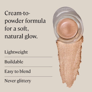 A small round container of MINORI - CREAM HIGHLIGHTER, CHAMPAGNE with a pink lid is shown partly open, revealing the shimmery champagne cream inside for a natural glow.