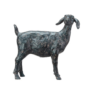Two small black sculptures of goats from CREATIVE COOP's RESIN GOAT WITH CAST IRON FINISH collection placed on a light-colored surface create the perfect rustic accent. One goat is standing while the other is lying down, surrounded by scattered grains. The background features a soft, light blue-gray wall, making this scene ideal for animal enthusiasts and elegant goat decor.