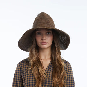 The WYETH Lina Raffia Sun Hat in Chocolate features a packable, ultra wide brim and slightly pointed crown, shown against a plain white background.