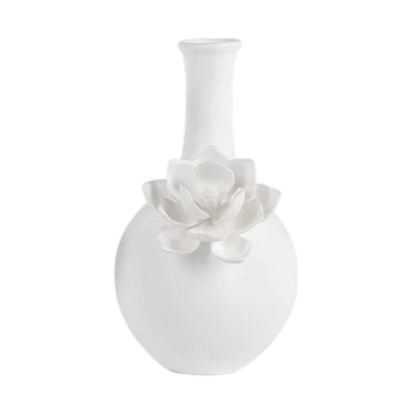The CAMEO LONG NECK PORCELAIN BUD VASE by ZODAX is a round, white vase with a matte finish, featuring a narrow neck and a detailed floral embellishment on the front.