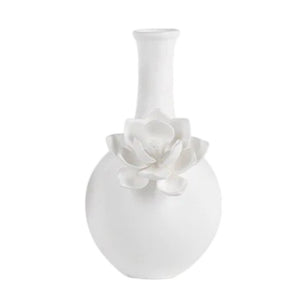 The CAMEO LONG NECK PORCELAIN BUD VASE by ZODAX is a round, white vase with a matte finish, featuring a narrow neck and a detailed floral embellishment on the front.